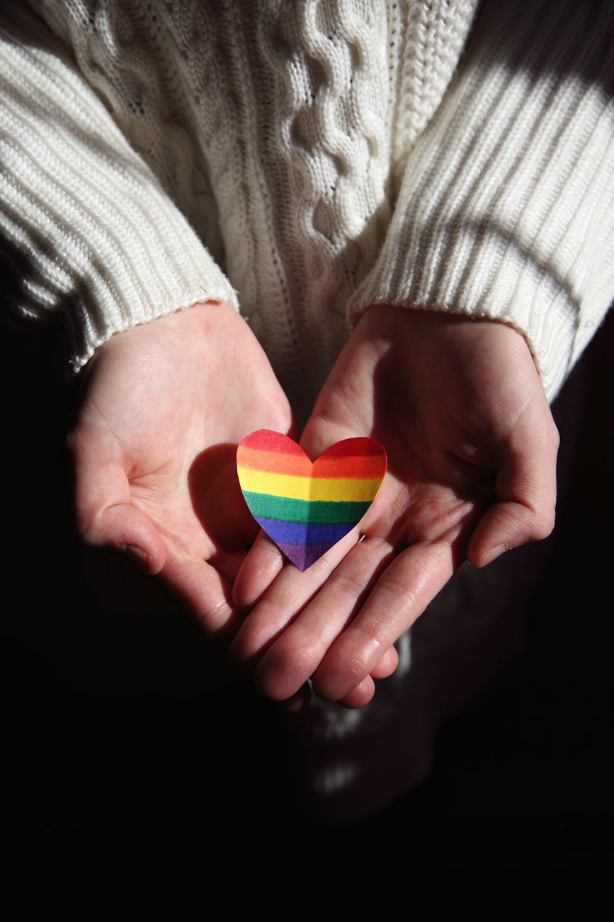 person holding multi colored heart shaped ornament